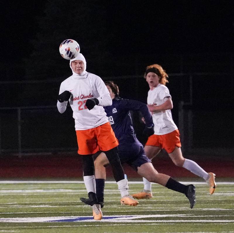 St. Charles East's Garrett Melton (22) heads the ball off a  New Trier goal kick during the class 3A St. Charles North Boys Soccer Supersectional match at St. Charles North High School on Wednesday, Nov. 1, 2023.