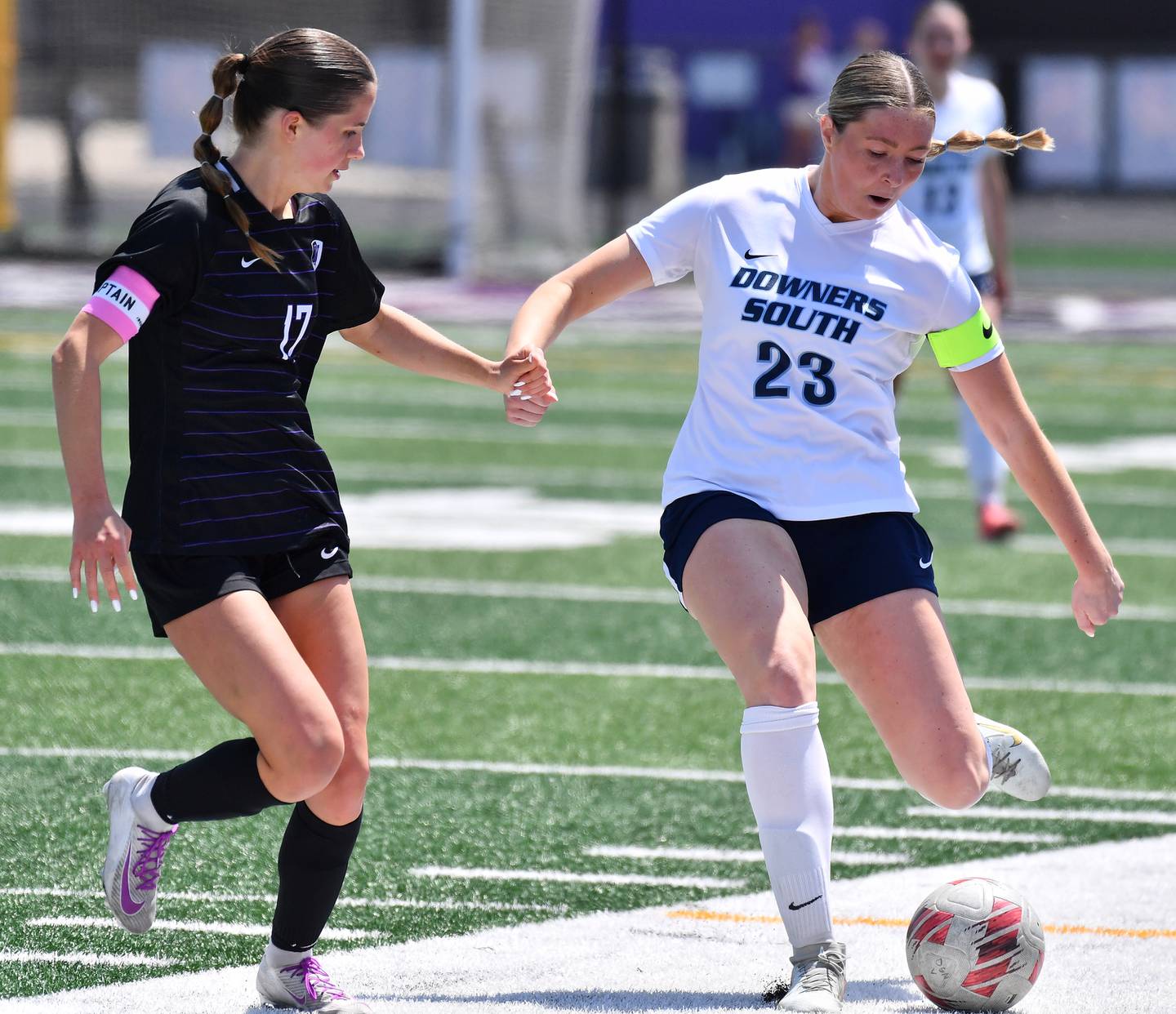 Downers Grove South’s Ashley Molinari (23) kicks the ball as Downers Grove North’s Lexi Keown defends during a game on May 10, 2025 at Downers Grove North High School in Downers Grove .