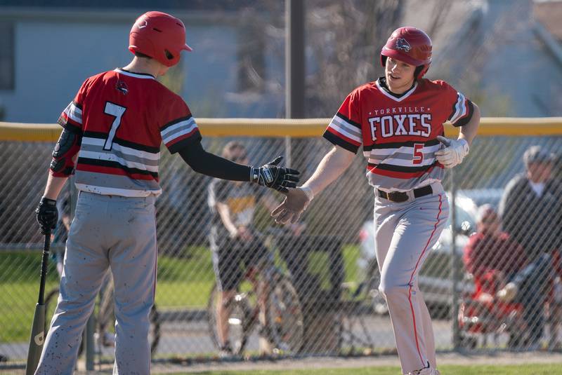 Yorkville's Ryan Buck (5) is greeted at home by Ryan Harris (7) after hitting a homer against Plainfield North during a baseball game at Plainfield North High School on Thursday, April 21, 2022.