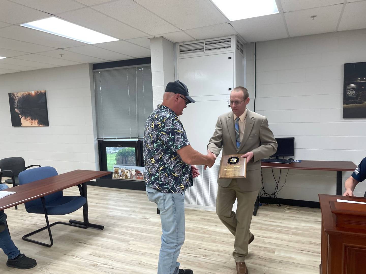 Utica Mayor David Stewart (right) shakes hands with retiring Utica Police Chief Rod Damron, whom he presented with a commemorative plaque on Thursday, May 11, 2023.