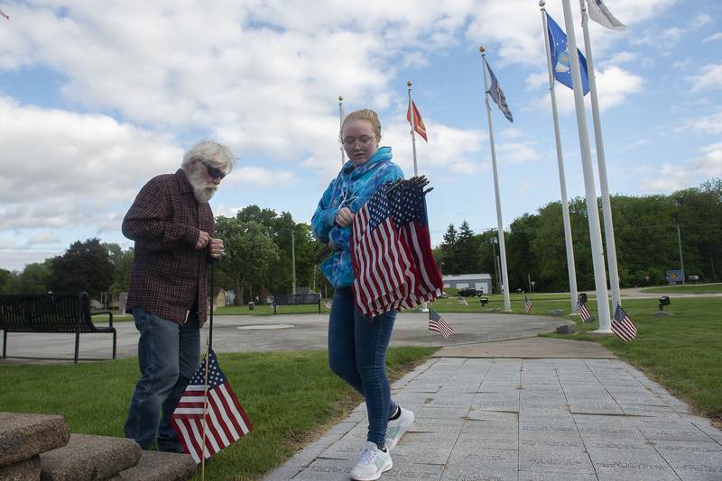 Gary DeBord and granddaughter Grace work to plant flags at Veterans Memorial Park in Dixon in recognition of Memorial Day on Friday, May 27, 2022.