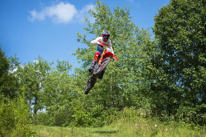 Cody Barnes soars over a hill while training on a course Thursday, August 4, 2022 near Fenton. Barnes will be traveling overseas later this month to participate in an international motocross competition.