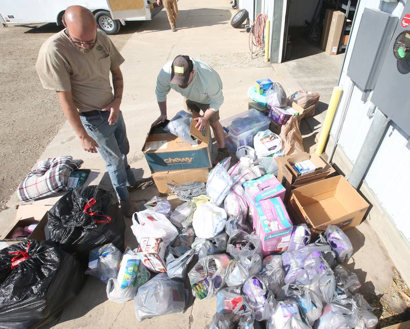 Elemore Electric employees Sky Abrassart and Nolan Drake  grab donated supplies before leaving for North Carolina on Friday, Oct. 4, 2024 at their shop in Dover. The crews are taking two trucks and two trailers full of equipment and supplies to Hendersonville and Spruce Pine N.C. to assist in the Hurricane Helene relief efforts.