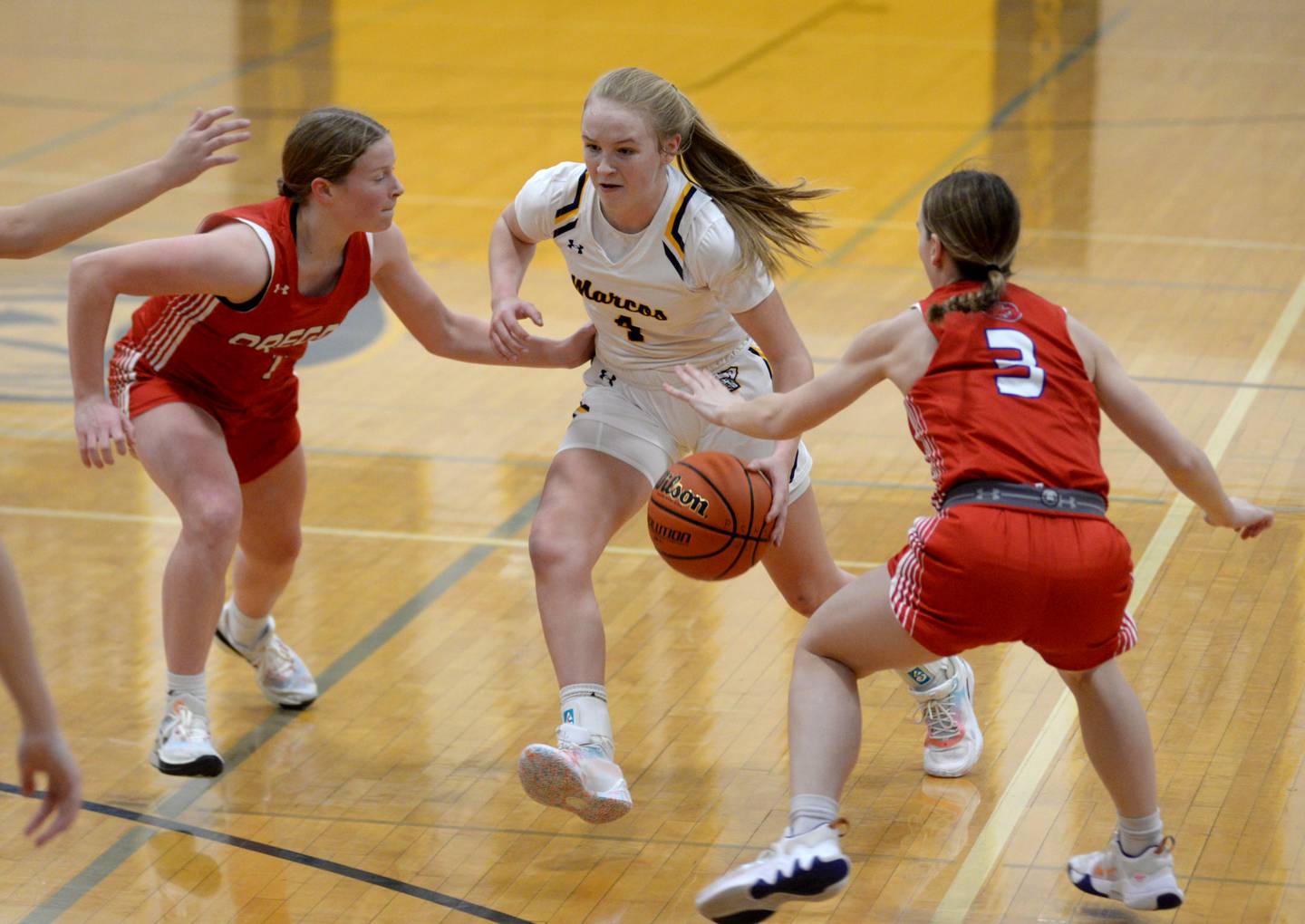 Polo's Camrynn Jones (4) drives to the basket against Oregon's Madison Shaffer (1) and Ella Dannhorn (3) during a Tuesday, Dec. 5, 2023 game at Polo High School.