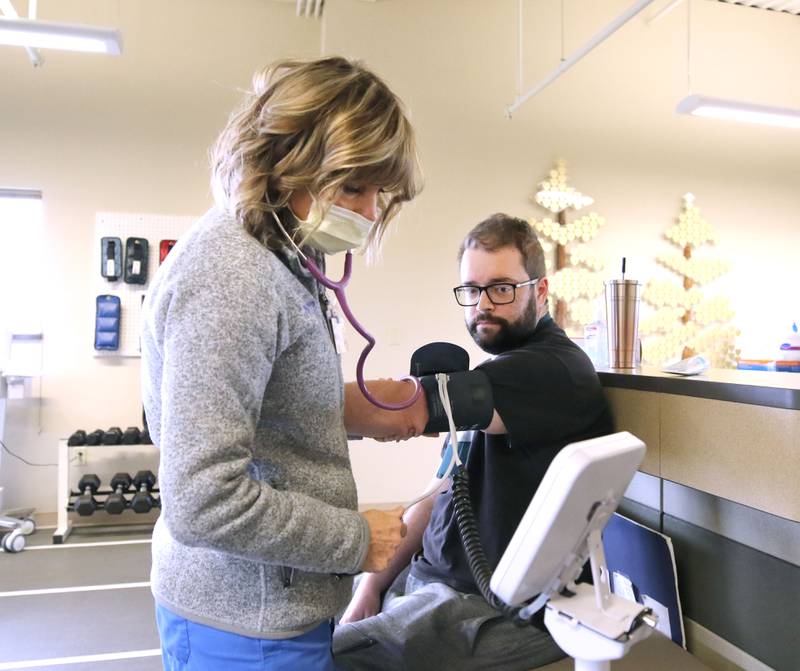 Nick Thielk, 30, has his blood pressure taken by Lisa Cowan, a registered nurse, prior to his rehabilitation session Friday, Nov. 19, 2021, in the Cardiac Rehabilitation Gym at Northwestern Medicine Kishwaukee Hospital in DeKalb. Thielk received a heart transplant in August.