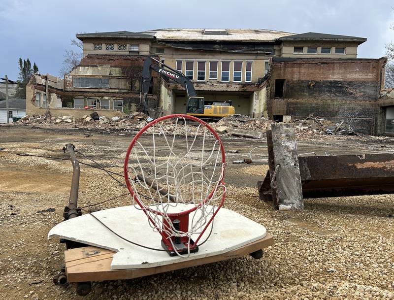 A basketball backboard and hoop sits outside in a parking lot as workers from Fischer Excavating, of Freeport, demolish the north part of the Congress School, 208 N. Congress Ave., on Friday, March 28, 2025 in Polo.. Demolition of the older, larger portion of the building has tentatively been set to begin Monday.