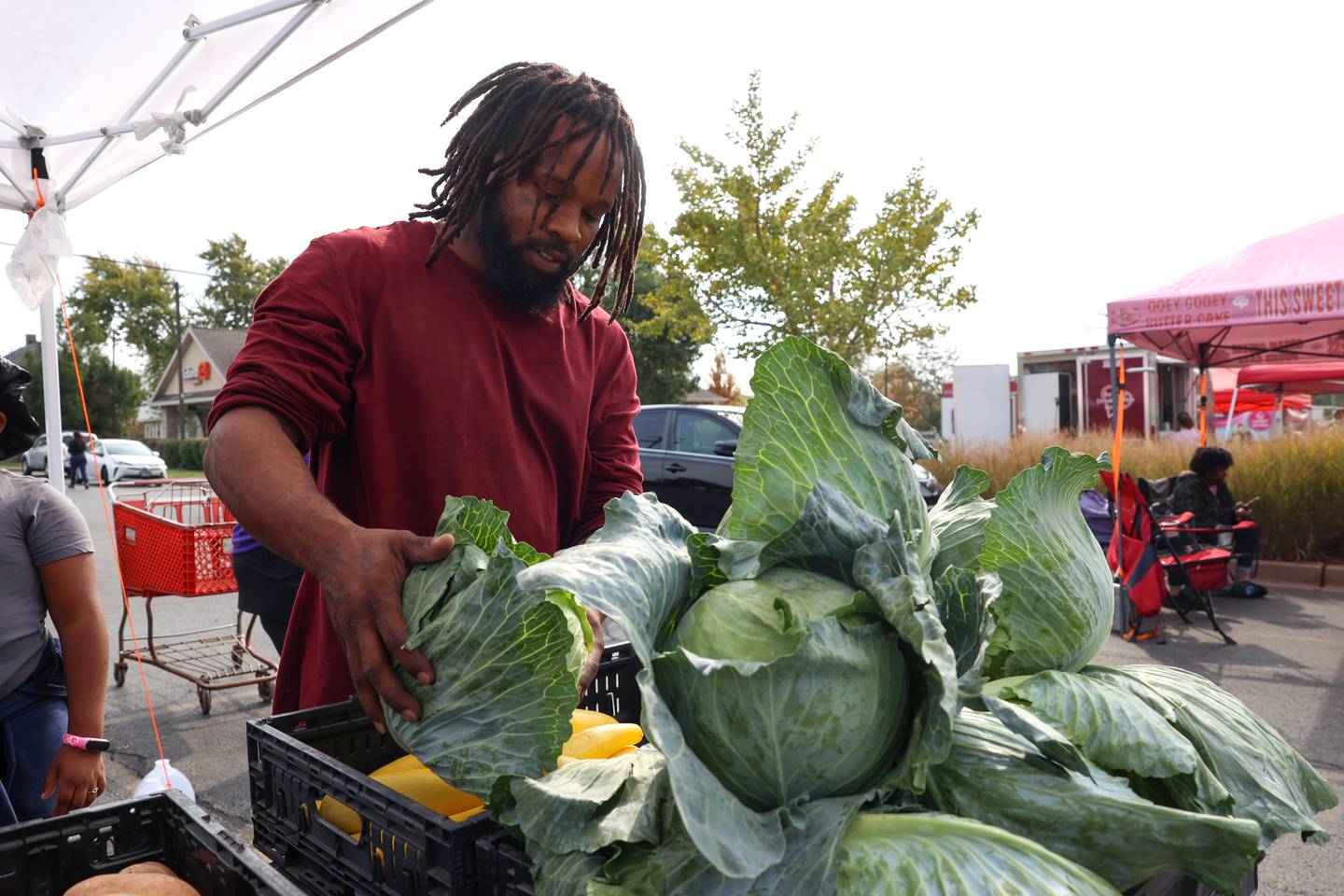 Jacob Thurman, son of longtime Pembroke produce farmer John Thurman restocks cabbages at the Kankakee Farmers' Market at the Thurman stand on Saturday, Oct. 18, 2025.
