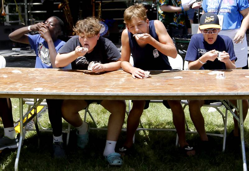 Kids stuff ice cream in their mouths as they compete in the ice cream eating contest during Lakeside Festival on Friday, July 5, 2024, at the Dole.