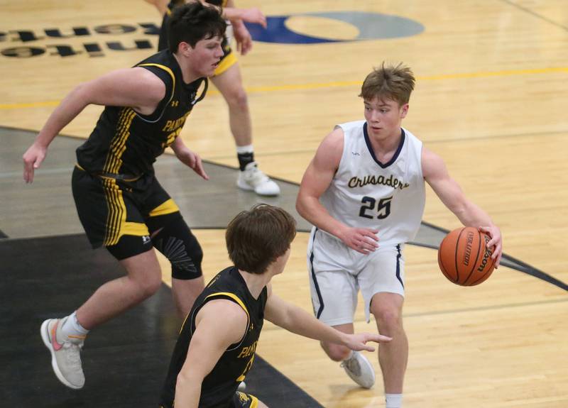 Marquette's Peter McGrath dribbles around Putnam County defenders Jaden Stoddard and Owen Saepharn during the Tri-County Conference Tournament on Tuesday, Jan. 23, 2024 at Putnam County High School.