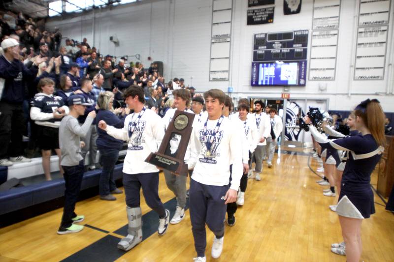 Players march into the main gym during a celebration of the IHSA Class 6A Champion Cary-Grove football team at the high school Sunday.