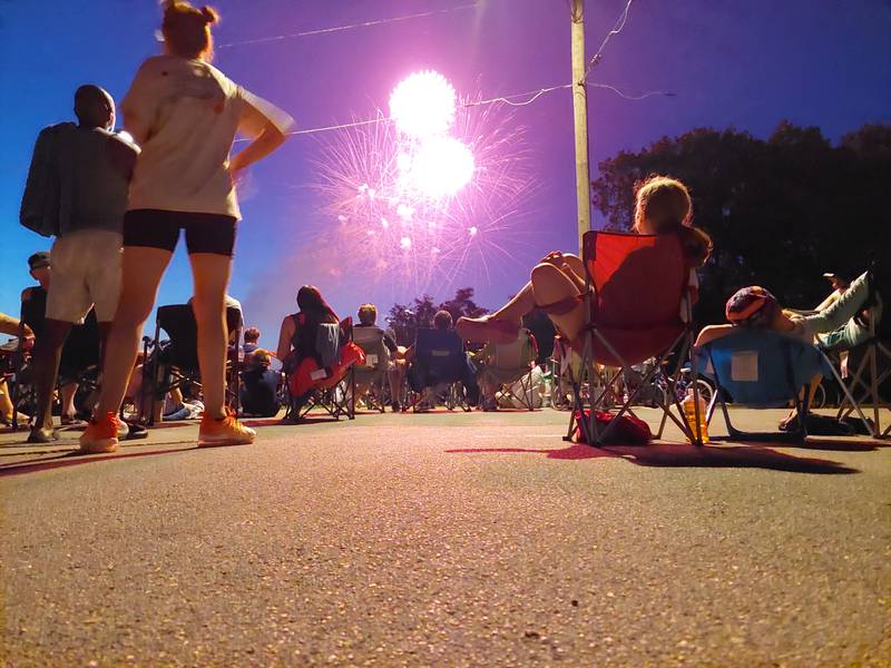 Independence Day fireworks explode over the sky Tuesday, July 4, 2023, at Ottawa High School as spectators watch from across the Illinois River.