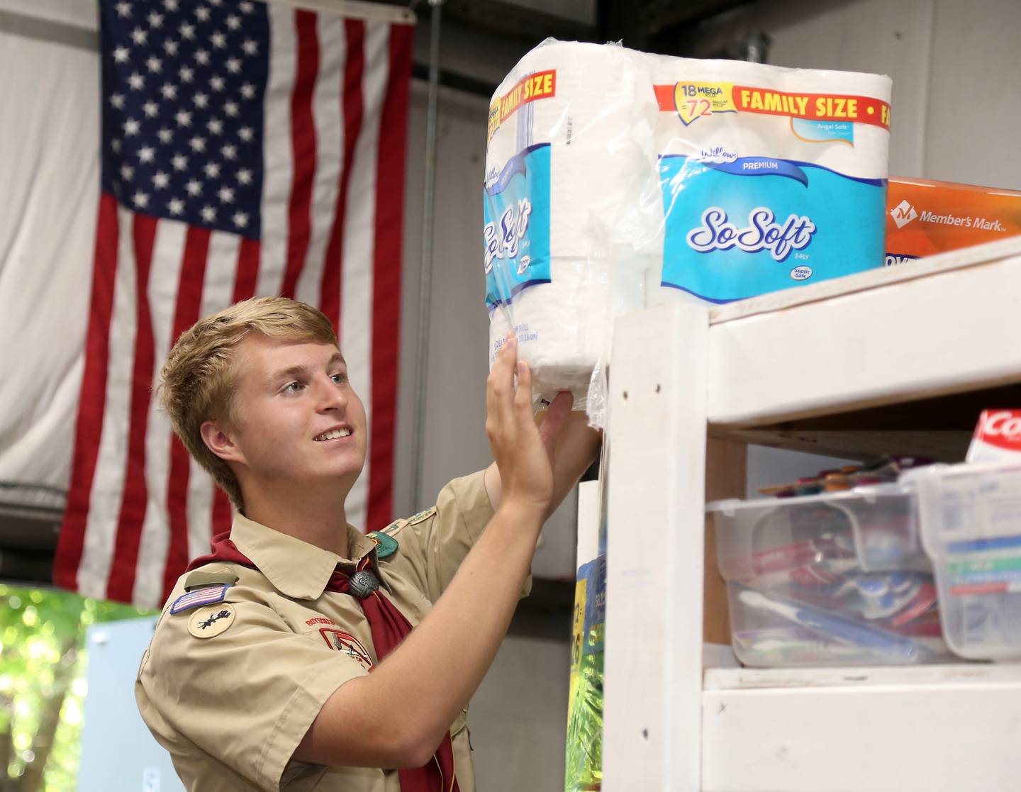 Billy Eby stores food on shelves he built as part of his Eagle Scout project at the Between Friends food pantry in Sugar Grove, Wednesday, June 8, 2022.