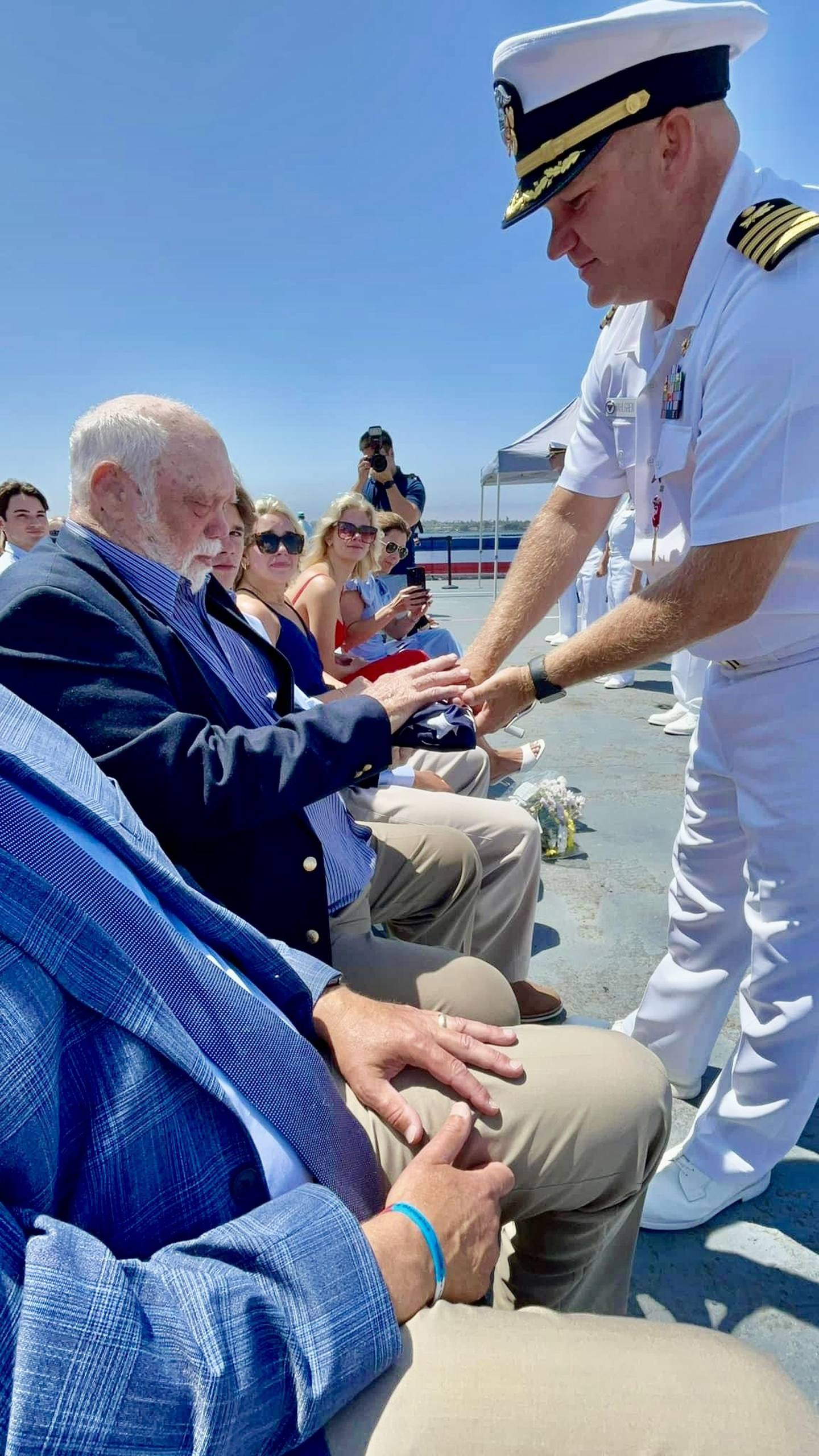 Princeton native Kristian Wahlgren, who retired after 25-years of service with the U.S. Navy, presents a U.S. flag to his father, Lee, during his retirement ceremony on July 19 in San Diego.
