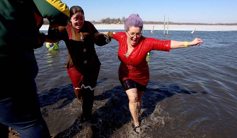Lori Smith of Mundelein gets a hand exiting the water Sunday, Feb. 20, 2022, during the Polar Plunge in Fox Lake. "It's always a shock," said Smith, who was taking her 10th polar plunge. Smith, who raised more $3,500 for the event, said her hot water heater at home has been broken the last five days, allowing her an advantage of sorts.