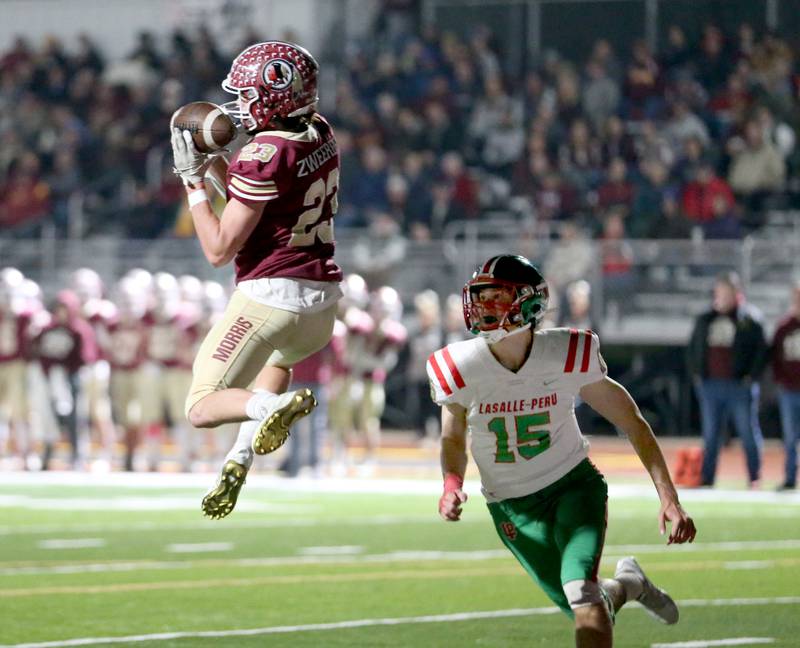 Morris' A.J. Zweeres (23) leaps to haul in a touchdown with La Salle-Per's Brendan Boudreau (15) in coverage during their Class 5A first-round football game Friday, Oct. 28, 2022, in Morris.