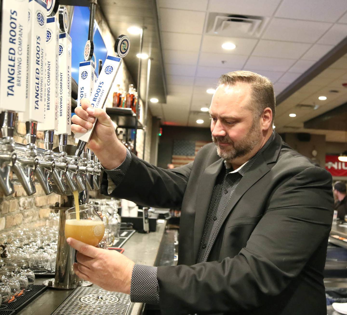 Scott Struchen, one of the founders and chief commercial officer of Keg & Kernel by Tangled Roots Brewing Company, pours a beer Wednesday, Dec. 8, 2021, after a ribbon cutting at the restaurant at 106 East Lincoln Highway in DeKalb. The official opening will be Saturday Dec. 11