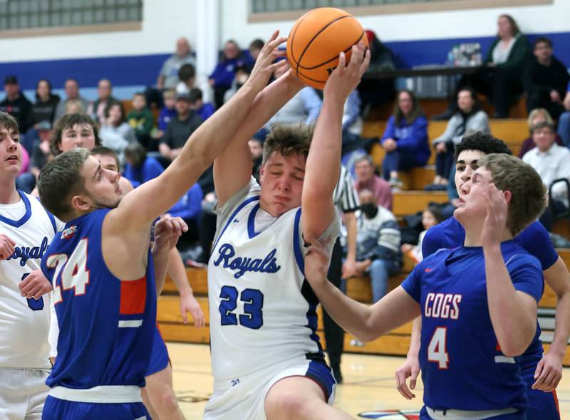 Hinckley-Big Rock's Luke Badal grabs a rebound between Genoa-Kingston's Peyton Meyer (left) and Cody Cravatta during their game Tuesday, Jan. 7, 2025, at Hinckley-Big Rock High School.