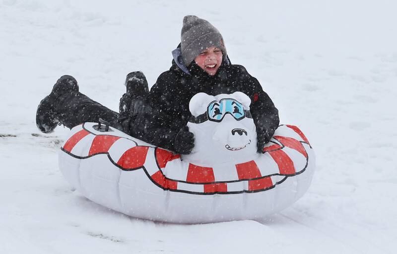 Parker Weller, 11, from DeKalb heads down the sled hill Tuesday, Jan. 9, 2024, at Hopkins Park in DeKalb. Several inches of heavy, wet snow Tuesday was a headache for some and fun for others.