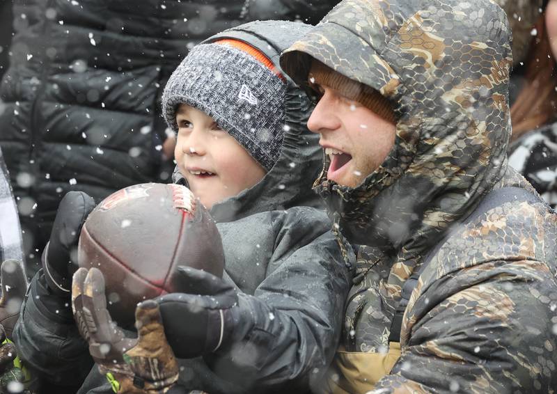 Mack Nollin, 4, and his dad Luke, from Vollo, react as Chicago Bears wide receiver DJ Moore gives them a ball after he scored a touchdown during the game against the Atlanta Falcons Sunday, Dec. 31, 2023, at Soldier Field in Chicago.