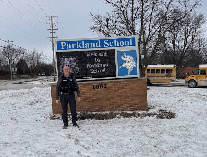 McHenry Police Officer Jim Harris in front of the Parkland School sign. Harris is battling metastatic prostate cancer.