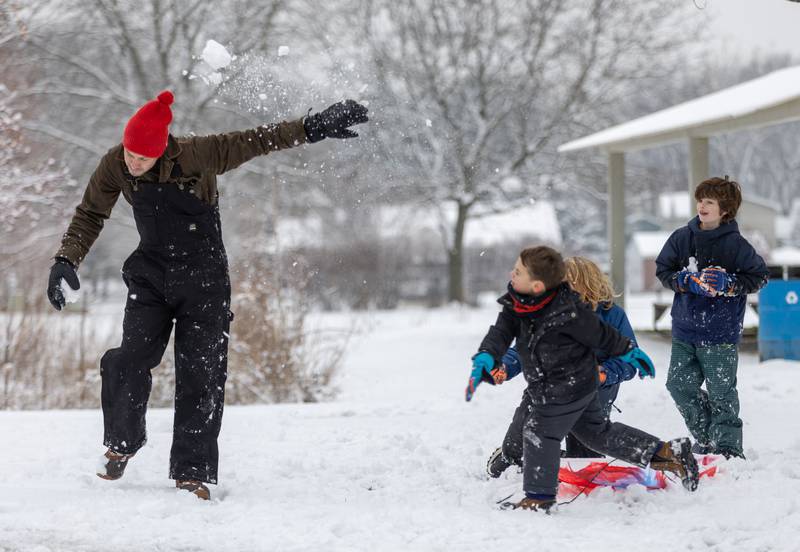 Joe Scigouski left, thrown by his son Eddie Scigouski (middle), 5, in Prairie Lathem Park in Batavia on Saturday, Jan. 6, 2023. The Kane County Area received about one to two inches of snowfall late Friday night into Saturday morning.