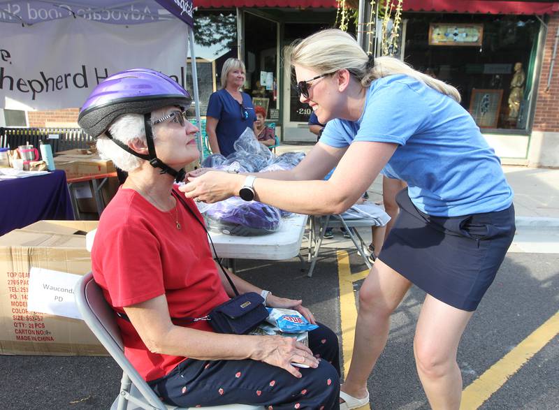 Marcia McWilliams, of Wauconda gets a free bike helmet fitted by Emily Hendler, a nurse with Advocate Good Shepherd Hospital, during National Night Out on Main Street on Tuesday, August 1st in Wauconda.  
Photo by Candace H. Johnson for Shaw Local News Network.