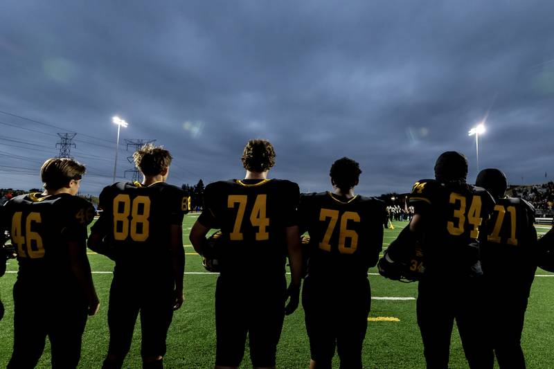 Joliet West’s varsity football team stands for the National Anthem prior to a game against Plainfield East at Joliet West on Oct. 10, 2025.