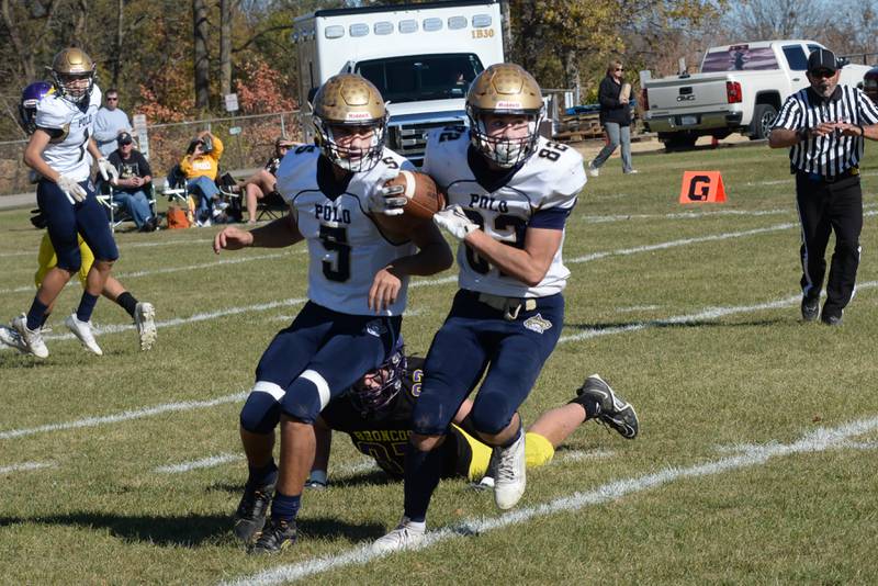 Polo's Gus Mumford (5) watches as his teammate, Kallin Gulbranson (82), picks off a pass against Orangeville on Saturday, Oct. 26, 2024 action at Orangeville. The Marcos finished the regular season in 8-man football undefeated. The state playoffs begin this week.