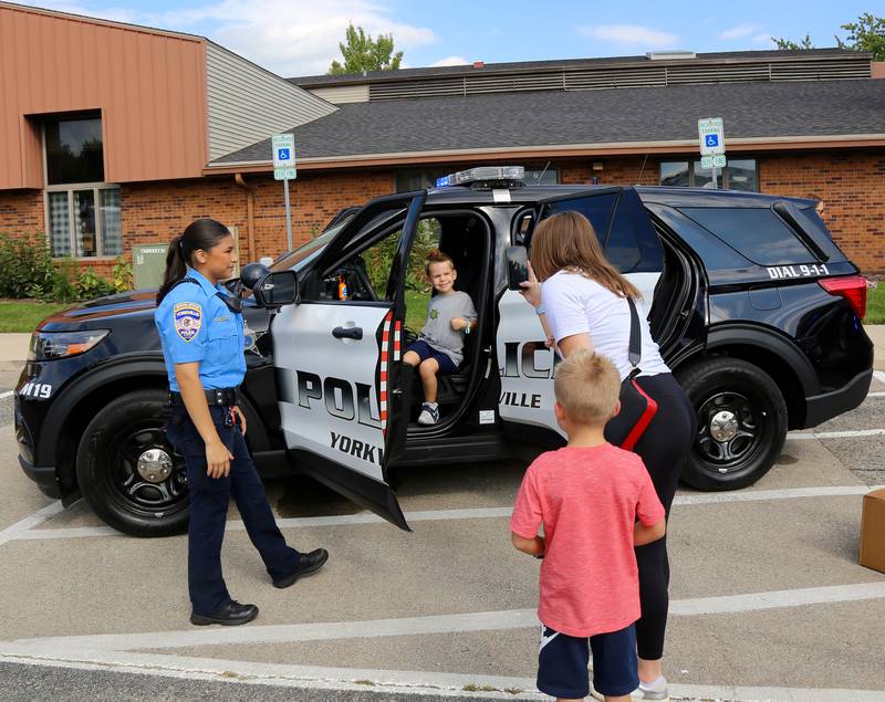 Rachel Johnson takes a photo of her son Maverick in a Yorkville Police Car while brother Jett looks on at the Touch a Truck event held at Yorkville's Hometown Days festival at Beecher Community Park at 908 Game Farm Road, Yorkville on Saturday, Aug. 30, 2025.