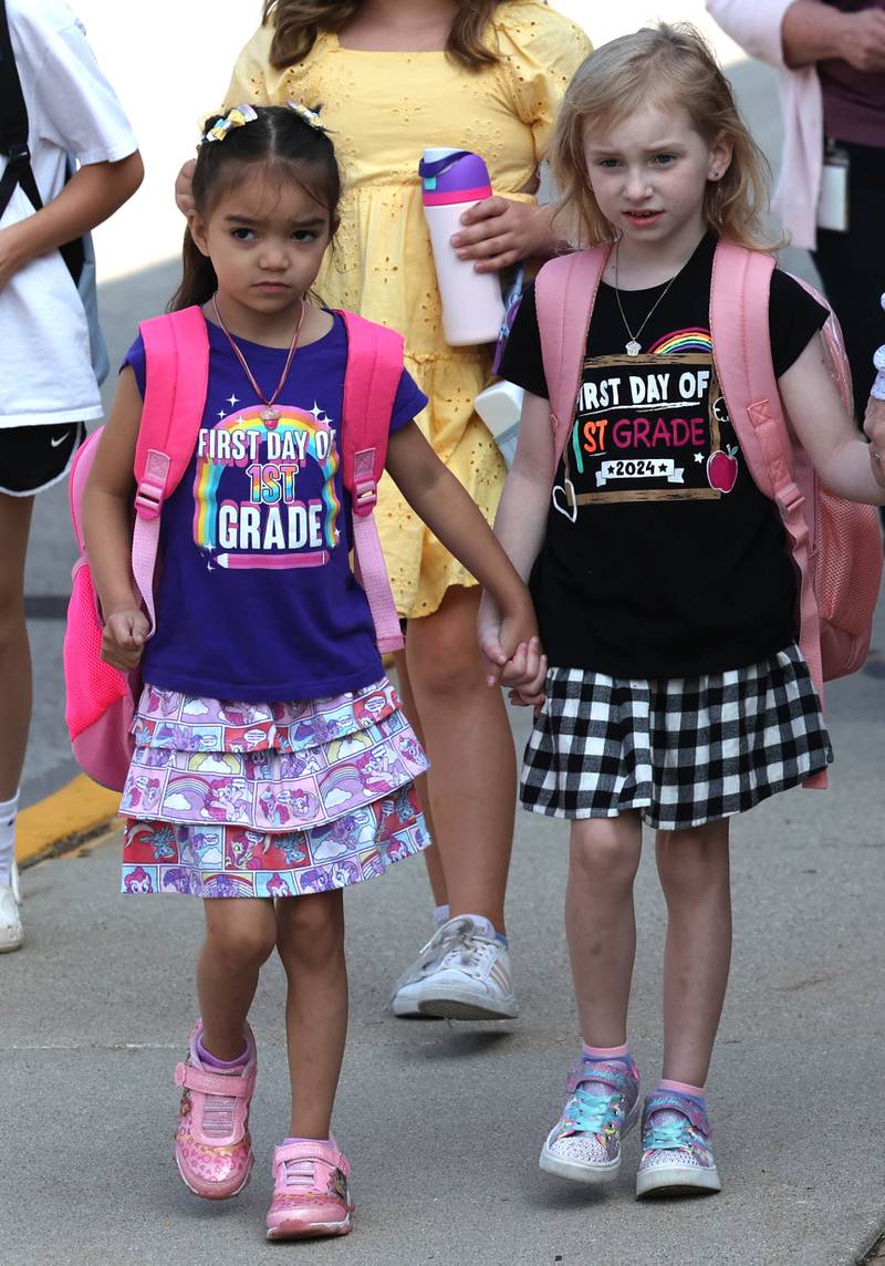 Bella Biacan, (left) and her cousin Charlie Bruder, both first graders at Southeast Elementary School, arrive on first day of classes Thursday, Aug. 21, 2024, at the school in Sycamore.