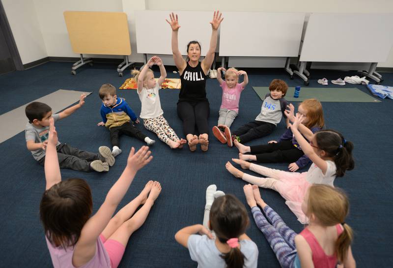 Leah Vaughan of La Grange Park and children ages pre K -2nd participate in Earth Day Yoga at La Grange Park Library Sunday April 13, 2025. The event was held to celebrate Earth Day and included them pretending to be various earth related elements including a flower.