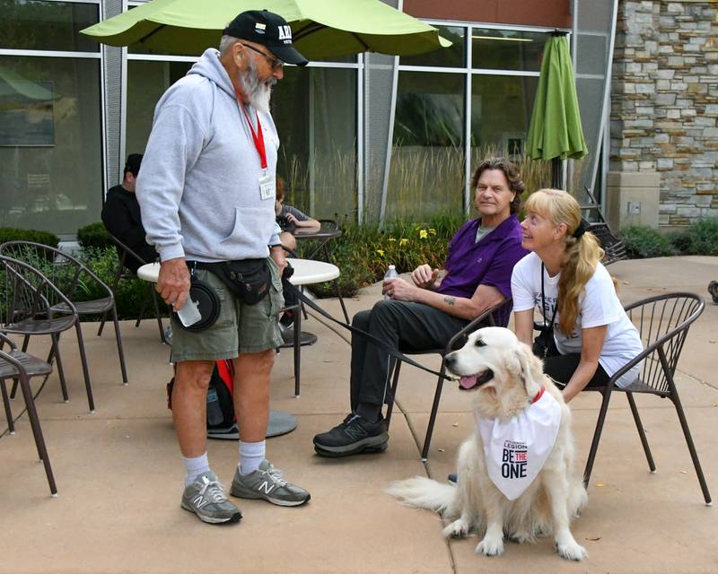Sharon Smith, right, of Geno pets Joey the golden retriever from Canine 4 Christ while talking with handler Dick Hilderbrant on Sunday Sept. 21, 2025, before the start of the Be the One Walk held at the Kishwaukee Health & Wellness Center in Sycamore.