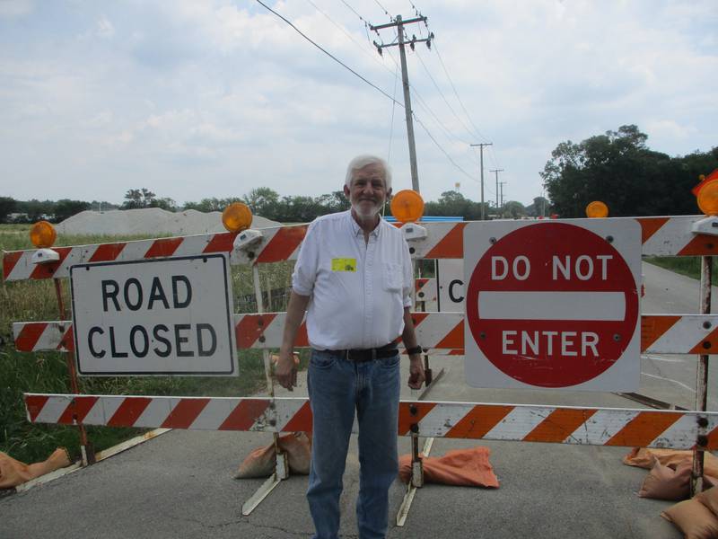 Steve Matter stands by the roadblocks that have shut down a section of New Lenox Road just outside the driveway to the house where he and his wife, Diane, live on July 8, 2025. Love's is building its Joliet truck stop kitty-corner from the Mattters' home and close to other houses that border the site.