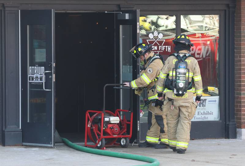 Oglesby firefighters use an exhaust fan to ventilate smoke near the Fire On Fifth entrance in the Westclox building on Tuesday, Jan. 20, 2026 in Peru. A working fire started in the storage room inside of Fire on Fifth. The fire started at 10a.m.  Fire departments from Utica, Oglesby Peru and La Salle all assisted on the scene. La Salle and Peru EMS were also dispatched. The entire Westclox building was evacuated. Two employees were transported by ambulance for smoke inhalation. A smoke detector inside Star Union Spirits triggered an alarm, prompting a fast response from firefighters.