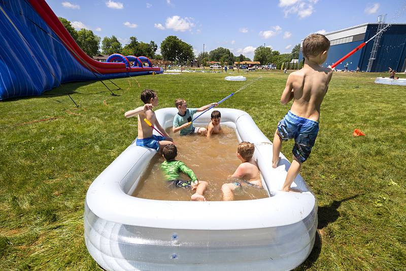 Unnoticed or uncaring, a group of boys play in water that has turned a nice shade of mud Tuesday, June 18, 2024 at Dixon Park District’s SPARK Camp.