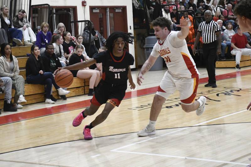 Momence's D'Angelo Hundley drives with the ball with St. Anne's Brandon Schoth guarding during St. Anne's 61-46 victory over Momence on Tuesday December 9, 2025.