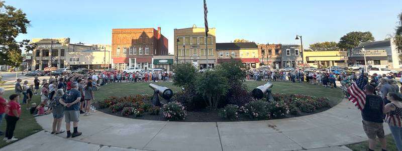 Attendees stand along the curved sidewalk on the east side of the historic Ogle County Courthouse in Oregon during a candlelight vigil for Charlie Kirk  on Sunday, Sept. 14, 2025.  An estimated crowd of 300-350 attended the hour-long evening event.