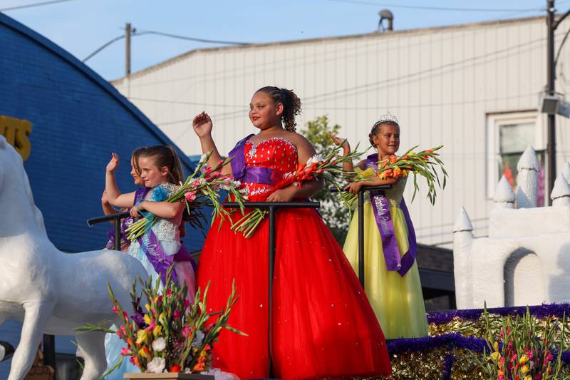 Tinley Isaacs, right, the 2025 Gladiolus Festival princess, waves to the crowd alongside fellow court participants during the 87th Momence Gladiolus Festival Main Street Parade on Friday, Aug. 8, 2025.