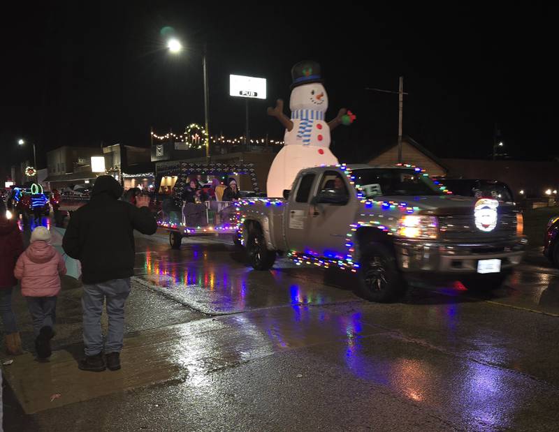 Parade goers wave at lighted floats Saturday, Dec. 14, 2024, during the Winter Wonderland parade in Oglesby.