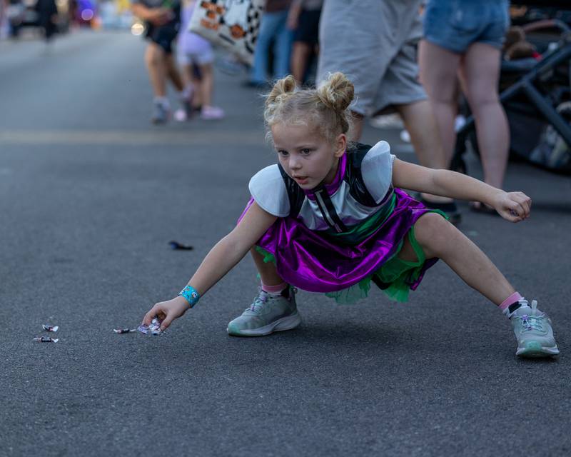 Kid picks up candy thrown from the annual Princeton Halloween Parade on Saturday, Oct. 4, 2025 on Main Street in Princeton.