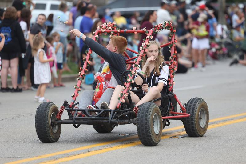 A girl drives the cart as her passanger tosses candy to the crowds in the Old Canal Days Parade on Friday June 7, 2024 in Lockport.