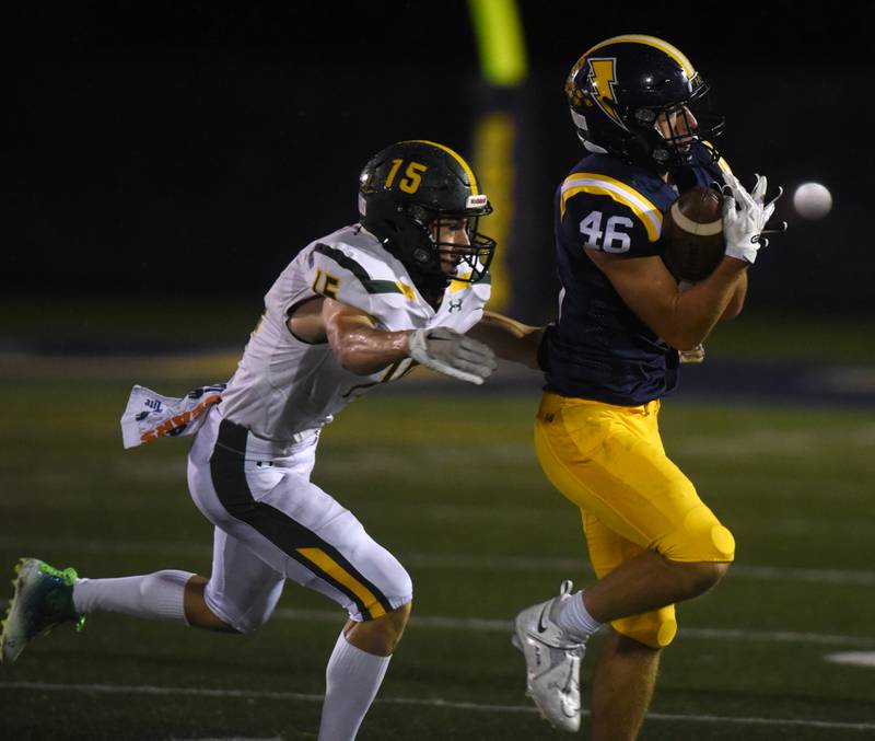 Glenbrook South’s Hank Leahy catches a pass ahead of Glenbrook North's Graham Gottschild during Friday’s game in Glenview.