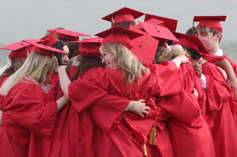 La Salle-Peru Township High School graduates hug each other after singing "Good Riddance" (Time of Your Life) during the L-P Class of 2026 commencement ceremony on Thursday, May 14, 2026 at Howard Fellows Stadium.