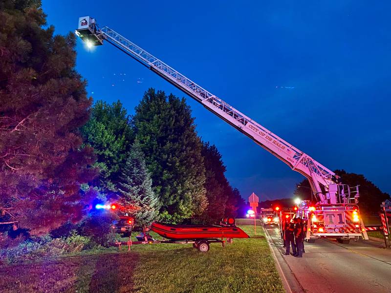 DeKalb firefighters are hoisted into the air on a ladder truck to help provide light to emergency divers undertaking a water rescue on Sunday, July 27, 2025, in the 600 block of Ridge Drive in DeKalb.