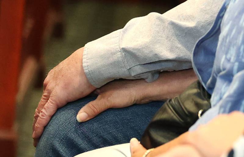 Members of the family of Patricia A. Wilson, 85 and Robert J. Wilson, 64, of Sycamore, hold hands as Jonathan Hurst, the man accused of beating to death the mother and son in August 2016, is escorted into Judge Marcy Buick’s courtroom at the DeKalb County Courthouse in Sycamore Monday, April 29, 2024, during a hearing on his case. Hurst is expected to stand trial for double murder in June, almost eight years after the killings and four years after his arrest.