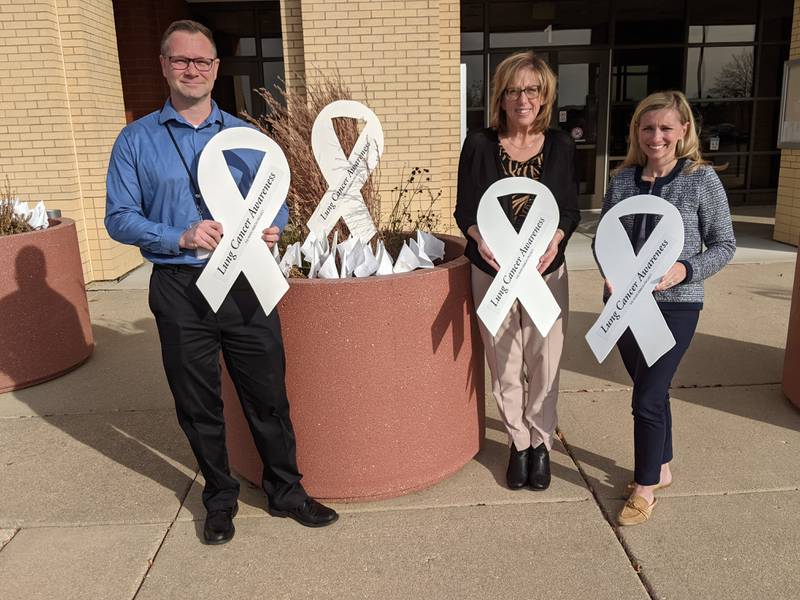 Aaron Rybski, environmental health services director for the Kendall County Health Department, far left, Michelle Hawley, mental health assistant director for the Kendall County Health Department, center, and Hillary Knowles, a nurse practitioner and lung screening navigator at Rush Copley Medical Center, far right, hold white ribbons as a symbol of unity. 
The Kendall County Health Department and Rush Copley Medical Center in Aurora are partnering to host a lung cancer awareness event from 9 to 11 a.m. Nov. 2 at Waterford Place Cancer Resource Center, 1310 Waterford Drive in Aurora.