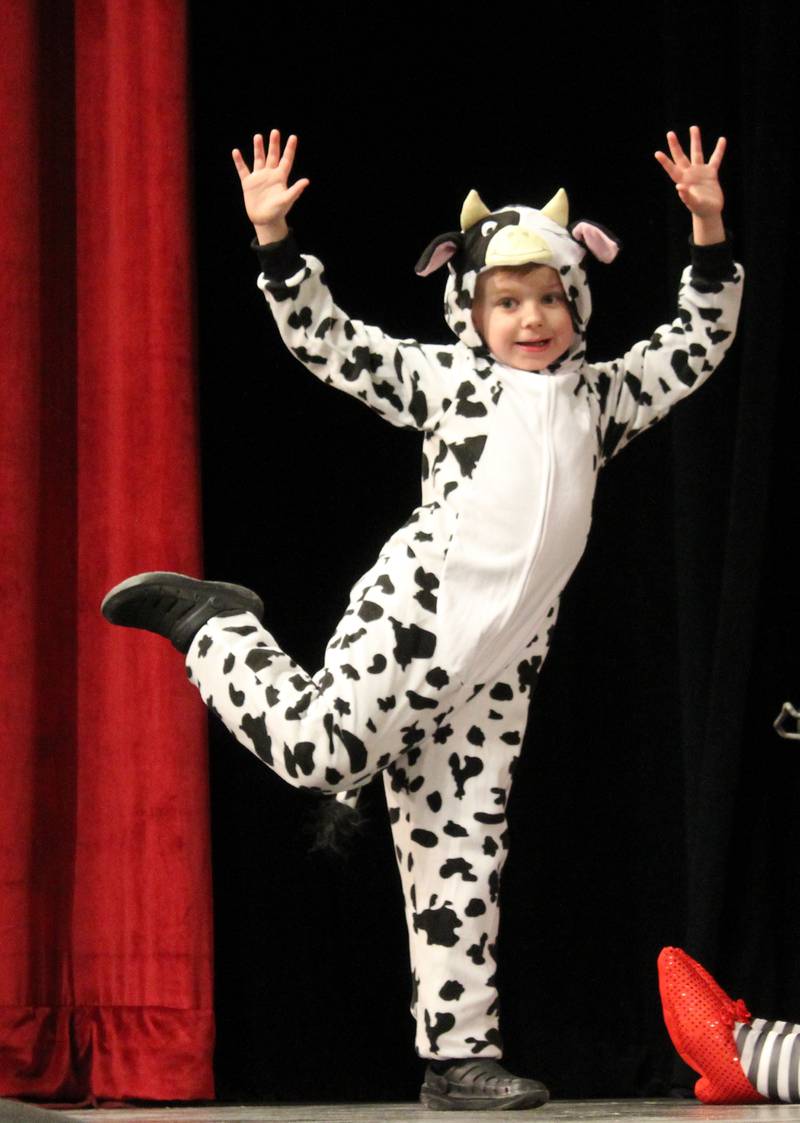 A cow caught in a tornado (Phoenix Jess) flies over the legs of the deceased Wicked Witch of the East on Friday, March 22, 2024, during the Streator Elementary Schools production of "The Wizard of Oz – Youth Edition" at Streator High School.