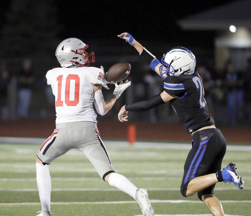 Palatine's Connor May (10) tries haul in a long pass as St. Charles North's Aidan McClure (26) pressures him Friday August 25, 2023 in St. Charles.