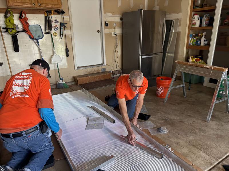 Home Depot employees Jim Doyle, left, and Jeff Porter help install a ramp at the Woodstock home of veteran Ben Jankowski June 6, 2025.