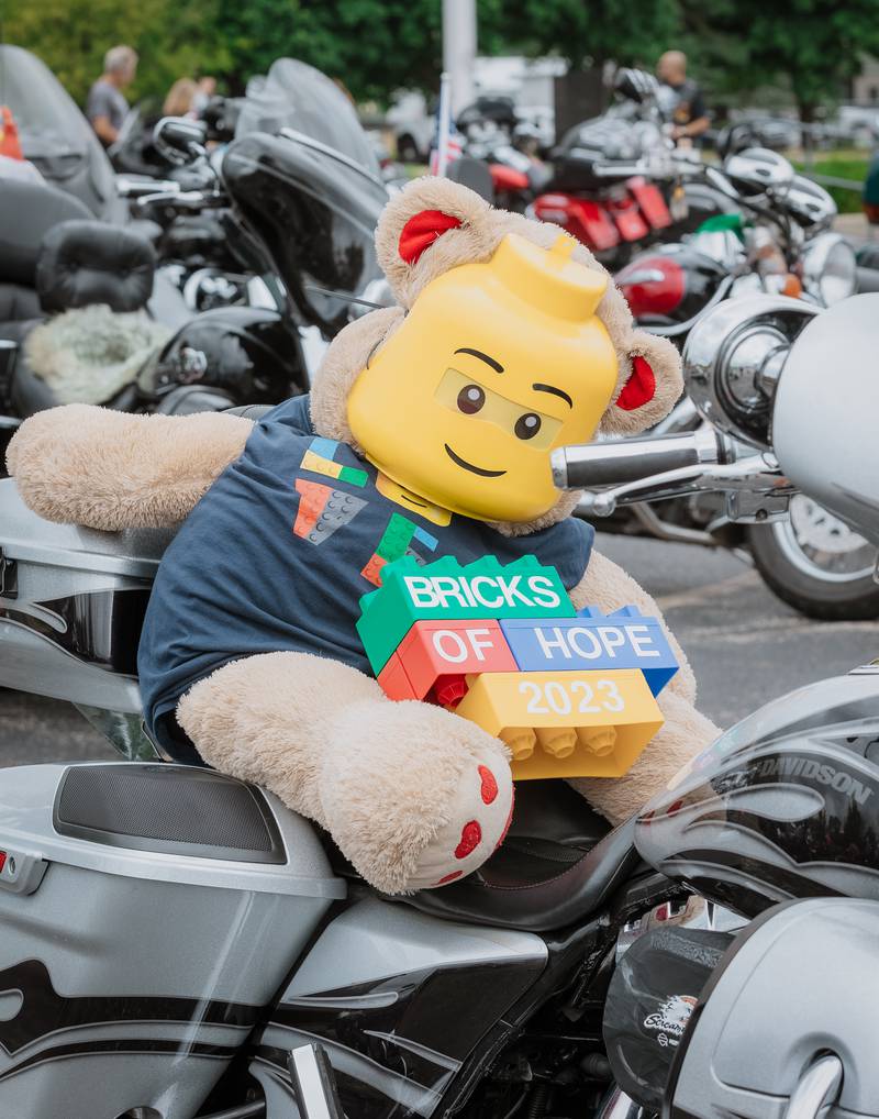 A teddy bear dressed in a Lego costume sits on a motorcycle during the Ride for Kids motorcycle charity ride for Bricks of Hope in 2023.